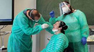 Weiteratmen und Mund öffnen: Kursleiterin Marianne Freund (r.) schult die Teilnehmer Thomas und Anika Weber, Schnelltests selbst durchzuführen.