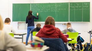 Schülerinnen und Schüler einer fünften Klasse der Johanniter-Realschule Heitersheim sitzen während des Unterrichts in ihrem Klassenzimmer.