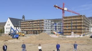 Bauleiter und Projektgruppe vor dem fertigen Holz-Rohbau: Im Herbst ziehen erste Bewohner ins neue „Collegium Academicum“ in der Südstadt.