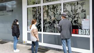 Claus Bunde (rechts) und zwei Passantinnen betrachten die neue Ausstellung in der Kunsthaus-Artbox.