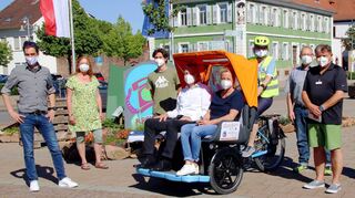 Mit dem Wind in den Haaren: Sabine Gärtner (TV Lampertheim) und Bürgermeister Gottfried Störmer nahmen als Erste Platz in der E-Rikscha. Ute Striebinger vom Seniorenbeirat steuerte als Pilotin die Probefahrt. Links: Dirk Dewald vom Stadtmarketing, das das Gefährt für drei Monate nach Lampertheim holte.