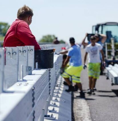 Bauarbeiter montieren auf der Salierbrücke eine Leitplanke.