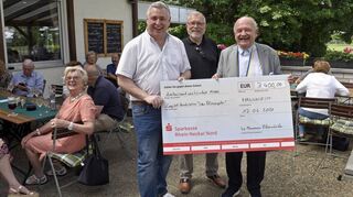 Bloomäuler unterstützen Blumepeter-Stück (v. l.): Thorsten Riehle, Bert Siegelmann und Klaus van Ackern, links am Tisch Inge Bichelmeier.