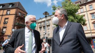 Winfried Kretschmann (v.l.) und Peter Kurz unterhalten sich während eines Gangs durch die Neckarstadt.