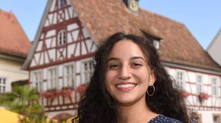 Strahlendes Lächeln, strahlender Sonnenschein: Die Linken-Kandidatin Zara Dilan Kızıltaş vor dem historischen Rathaus in Schriesheim.