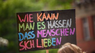 Eine Teilnehmerin hält im Rahmen des CSD (Christopher Street Day) auf dem Rathausplatz ein Schild („Wie kann man es hassen; dass Menschen sich lieben“) in die Höhe. Das traditionelle Straßenfest ließen die Veranstalter Corona-bedingt ausfallen. +++ dpa-Bildfunk +++