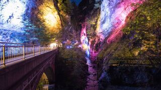 Die nachts bunt angestrahlte Tamina-Schlucht: Früher wurden Badegäste hier in Körben bis zum Quellwasser hinabgelassen.