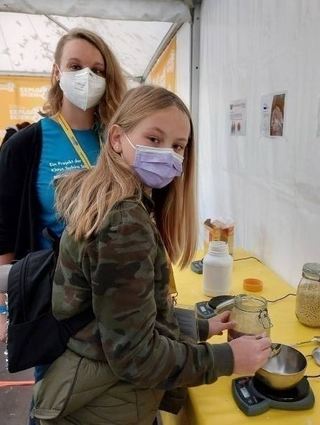 Lehrerin Mira Boehme vom Orgateam der Marie-Baum-Schule zeigt Anna Sophia Brandenburg, in welchem Verhältnis Lavendelaroma zugefügt wird.