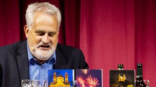 Bücher und Bier: Uwe Ittensohns Lesepult ist passend ausgestattet im Alten Stadtsaal. Die zwei Vorgänger von „Festbierleichen“ sind ebenfalls auf der Bühne.