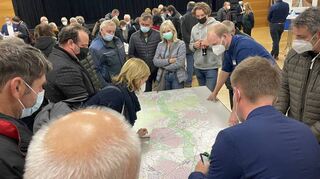Über den Plan gebeugt, der den grün eingefärbten Vorzugskorridor zeigt: Besucher der Infoveranstaltung zur geplanten Erdgasleitung.