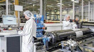 Im Kompetenzcenter für emissionsfreie Mobilität des Mannheimer Mercedes-Benz Werks arbeiten Beschäftigte an einem Wasserstofftanksystem.