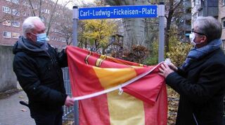 Ortsvorsteher Christoph Heller und Beigeordneter Andreas Schwarz enthüllen das neue Platzschild am Carl-Ludwig-Fickeisen-Platz.