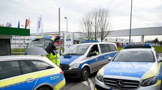 Fahrzeuge der Polizei stehen in Eppelheim vor dem Werk eines Getränkeherstellers. Dort hatte die Paketbomben-Serie begonnen.
