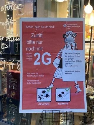 Ein Hinweisschild zur 2G-Regel vor einem Geschäft in Mannheim.