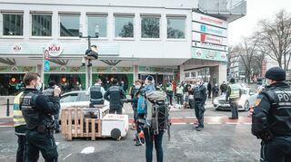 Bei der Blockade kletterte ein Aktivist auf eine Straßenlampe, andere schlossen sich an ein Automodell aus Pappe und Paletten an.