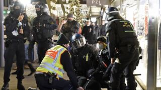 Polizisten setzen in den Quadraten einen Demonstranten nach einem Handgemenge mit den Sicherheitskräften fest.