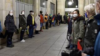Am Montagabend haben mindestens 400 Menschen ihre Solidarität mit Opfern der Corona-Pandemie mit einer Kette ums Rathaus gezeigt.