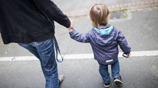 Eine Mutter hält ihren Sohn an der Hand. Alleinerziehende benötigen besonders häufig staatliche Leistungen in der Pandemie.