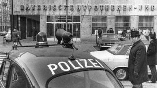Ein Polizeiauto steht am 21. Februar 1972 nach dem Überfall vor der Bayerischen Hypotheken- und Wechselbank am Ludwigshafener Ludwigsplatz.