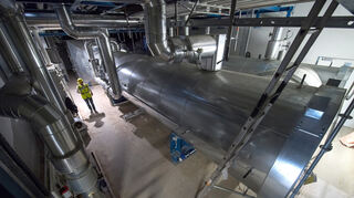 in Mitarbeiter der EnBW läuft im Neubau des Gaskraftwerkes Gaisburg an einem Wärmeüberträger für das Gaskraftwerk vorbei. (