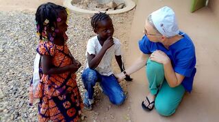 Die Ladenburgerin Dagmar Große-Wilde mit zwei Kindern an der Klinik des Vereins Operieren in Afrika in Burkina Faso.