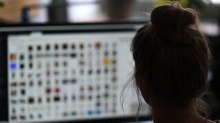 Eine Kriminaloberkommissarin sitzt in einem Büro vor einem Auswertungscomputer auf der Suche nach Kinderpornografie und Fällen von sexuellem Missbrauch.