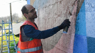 Künstler Christoph Gantner bei der Arbeit am Brückenpfeiler am Neckarkanal.