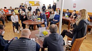 Auf einer Sitzung werden die Kriegsflüchtlinge über die Abläufe in der Unterkunft informiert, Dolmetscherin Anna German (rechts stehend) übersetzt.
