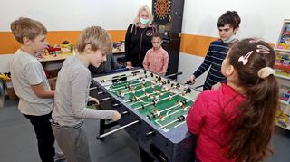 Kinder beim Tischkicker am Rande des Sitzungsraums.