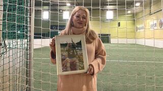 Christine Pradt mit einem ihrer Lieblingsfotos: Es zeigt ihren verstorbenen Mann Walter Pradt, wie ihn seine Spieler nach einem Aufstieg feiern.