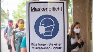 Nicht alle Schilder werden abgehängt: In einigen Häusern gilt unverändert die Maskenpflicht.