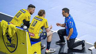 Löwen-Trainer Ljubomir Vranjes während des Spiels gegen Hamburg im Gespräch mit Juri Knorr und Jannik Kohlbacher (von rechts).
