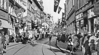 „Hochburg des völkisch-bornierten Nationalsozialismus“ konstatiert Frank Engehausen in seinem Buch über Heidelberg. Das Bild zeigt die Hauptstraße 1938 im „Schmuck“ von Hakenkreuz-Flaggen.