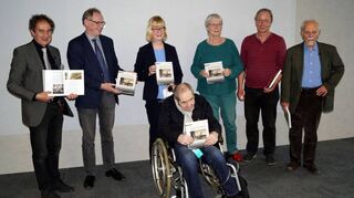 Reiner Schmidt (v.l.) überreicht die ersten Bände an Ulrich Nieß, Anja Gillen, Hans-Joachim Hirsch (im Rollstuhl), Barbara Ritter, Heiner Ritter und Erich Siebert.