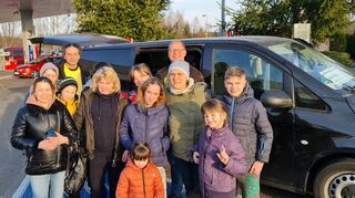 Cem Cetin (hinten l.) und Ralph Kaiser (hinten Mitte) mit einem Teil der geflüchteten Männer, Frauen und Kinder auf ihrem Weg nach Mannheim.