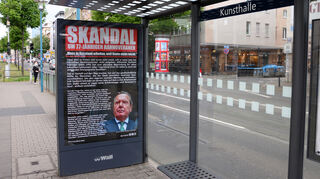 Ein Plakat mit der Kritik an Altkanzler Schröder an der Haltestelle Kunsthalle in Mannheim.