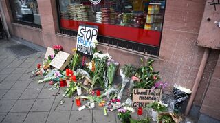 Am Tag nach dem Polizeieinsatz mit Todesfolge am Mannheimer Marktplatz haben Menschen Blumen und Schilder am Ort des Geschehens niedergelegt.
