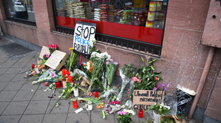 Blumen, Kerzen und Schilder liegen und stehen an dem Ort, an dem am Montag ein Mann nach einer Polizeikontrolle gestorben ist.
