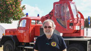 Markus Appel vor dem historischen Kranwagen der Feuerwehr.