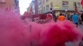 Menschen demonstrieren am Samstagabend in Mannheim gegen Polizeigewalt und zünden dabei Pyrotechnik.