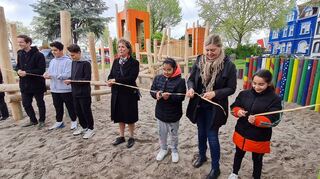 Umweltbürgermeisterin Diana Pretzell von den Grünen (Mitte) freut sich mit den Kindern und Lehrerin Jasmin Heuer (2. v.r.) bei der Spielplatz-Eröffnung.