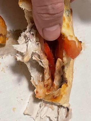 Diese Pizza wurde mit Verpackung im Teig ausgeliefert.