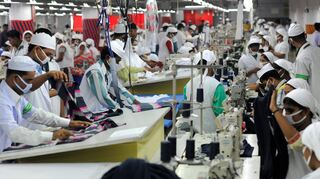 Das Archivbild zeigt Mitarbeiter einer Textilfabrik in einem Vorort von Dhaka (Bangladesch), die in der Produktion arbeiten und T-Shirts nähen.