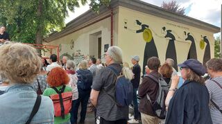 Hinterköpfe als Eindruck vom Einweihungsfest: Christina Laube ist ganz links (auf dem Podest) am Bildrand zu erkennen.