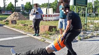 Ein Verkehrsteilnehmer zieht einen Aktivisten des Bündnisses „Letzte Generation“ bei einer Straßenblockade in Mannheim von der Straße.