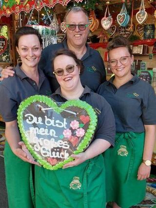 Jörg Barth mit seinen Töchtern Marika (v.l.), Melina und Benita verkaufen Lebkuchenherzen.