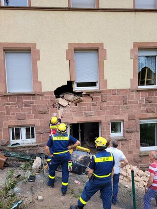 Einsatzkräfte des THW untersuchen das beschädigte Haus.