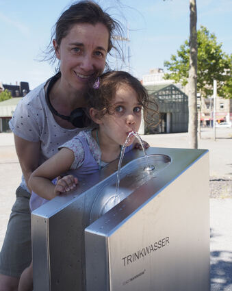 Miriam Adrian aus Mannheim und Tochter Carlotta nutzen den Trinkwasserbrunnen direkt am ersten Tag.