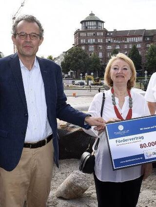 Georg Wacker (v.l.), Helen Heberer und Ralf Eisenhauer mit Riesenscheck.