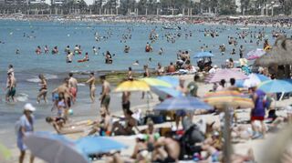 Menschen baden und sonnen sich am Strand auf Mallorca.